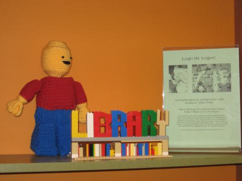 Crocheted Lego figure and Legos spelling library