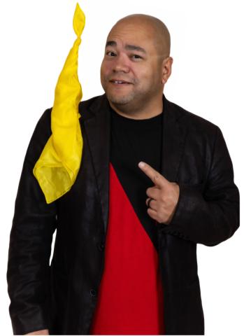 A man is pointing at a yellow scarf that appears to be floating in the air.