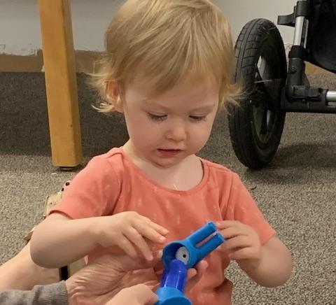 Young child playing with educational toy at storytime